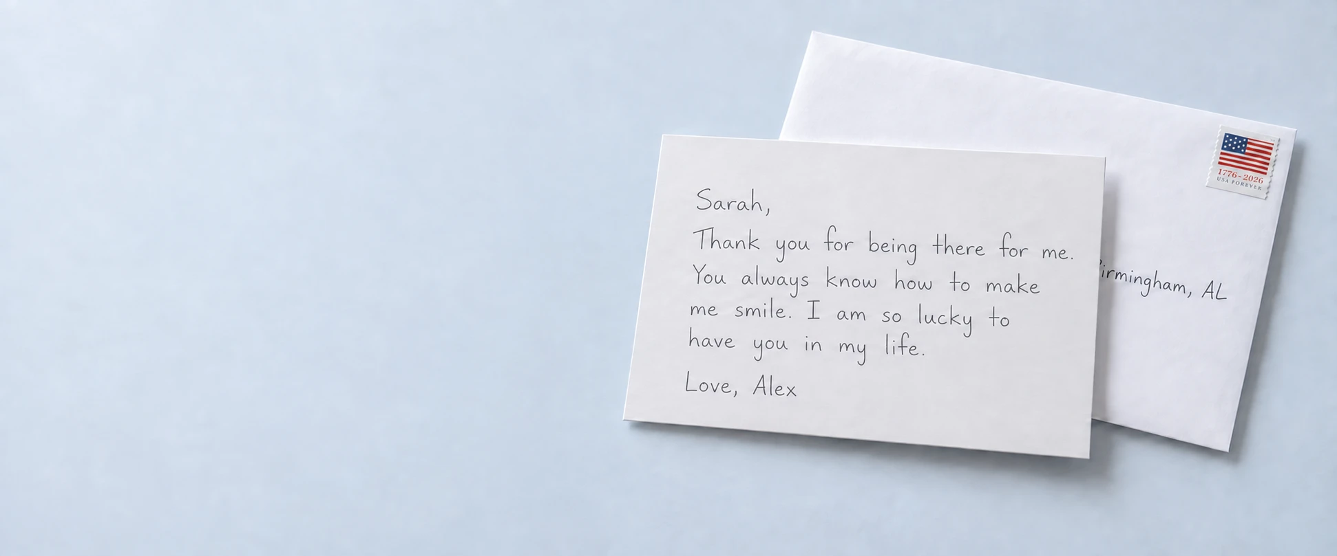 A white card with a personal note in pen, beside a stamped envelope